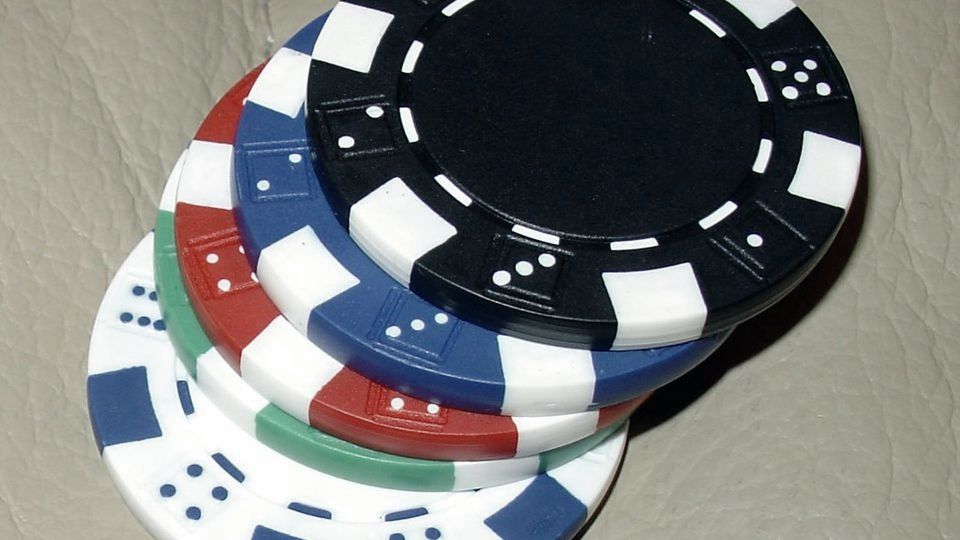 A small stack of poker chips including blue chips