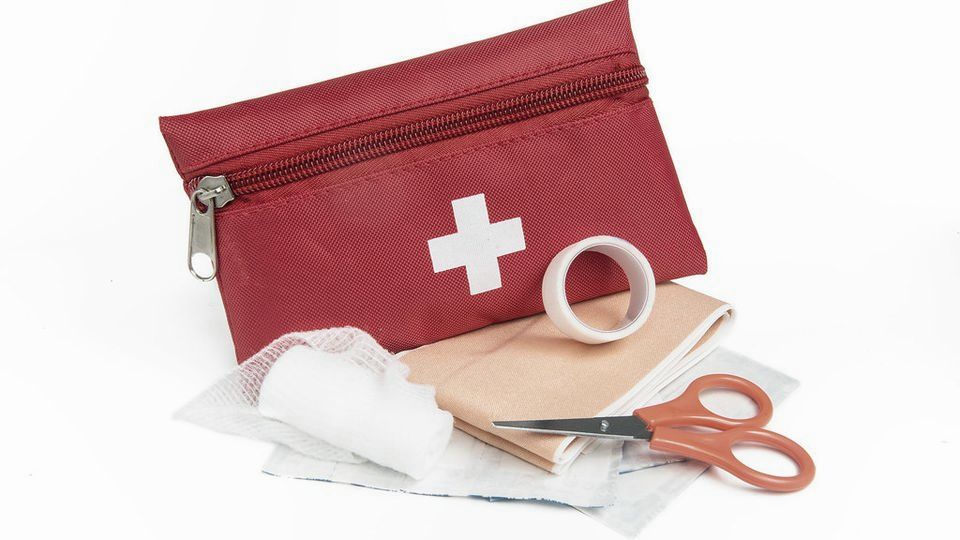 A red first-aid pouch with bandages and scissors