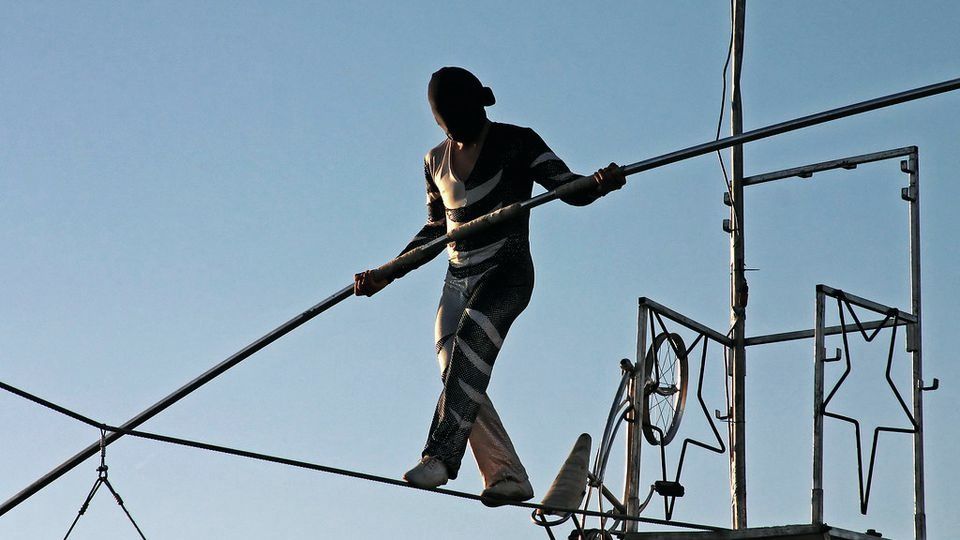 A tightrope walker balancing on a high wire